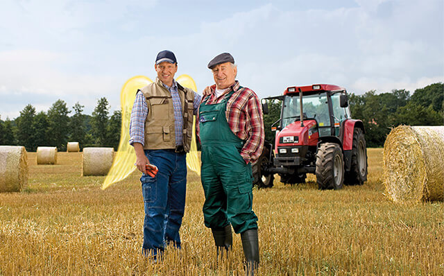 Zwei Landwirte stehen auf einem Heufeld mit Strohballen. Ein Landwirt hat Schutzengelflügel.